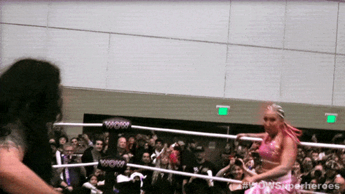 two women in a wrestling ring with wow written on the ropes