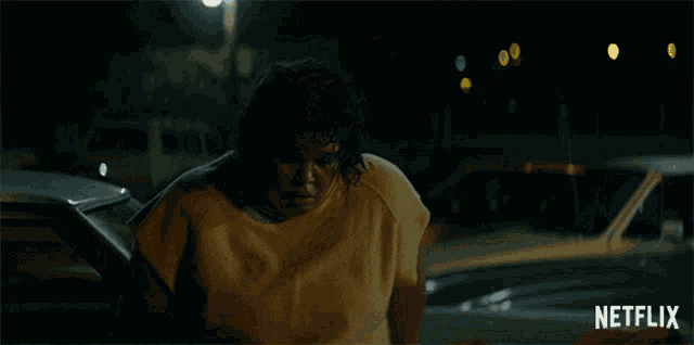 a man in a yellow shirt is standing in front of a netflix ad