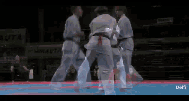 a karate match is being played in front of a sign that says mikauta