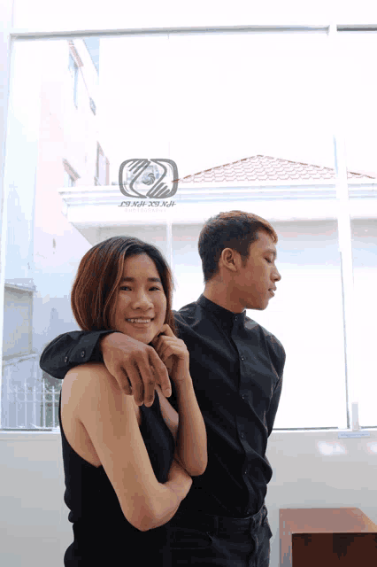 a man and a woman standing next to each other with a sign that says ' saigon design ' in the background