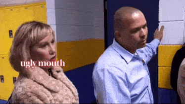 a man and a woman are standing next to each other in a locker room .