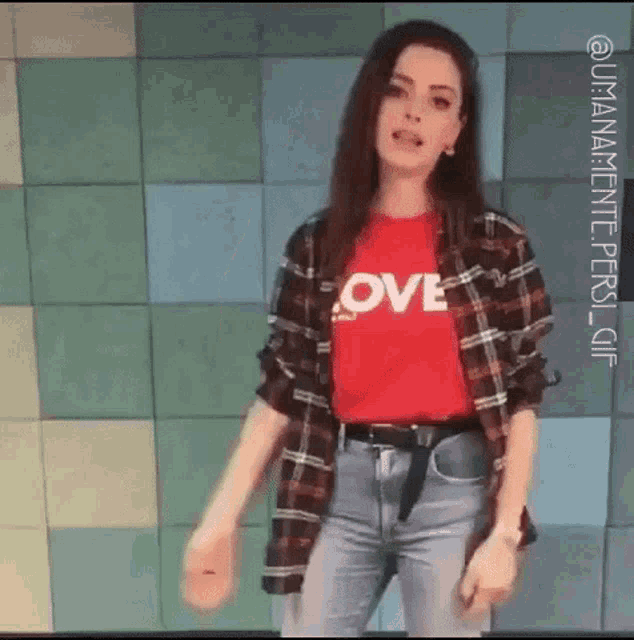 a woman wearing a red shirt with the word love on it is dancing .