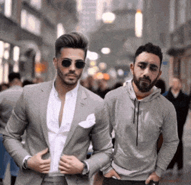 a man in a suit and a man in a hoodie are standing next to each other