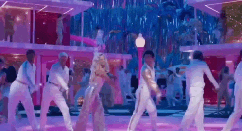 a group of people are dancing on a stage in a room .