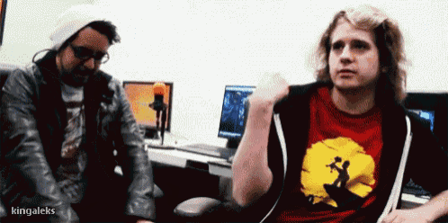 a man wearing a red shirt with the lion king on it talks to another man