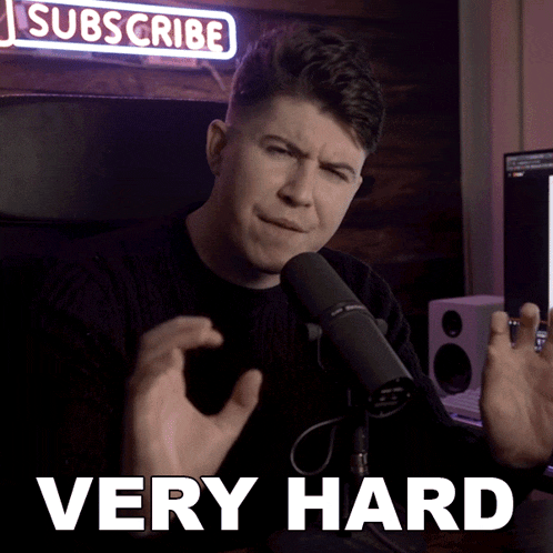 a man sitting in front of a microphone with a sign that says subscribe above him