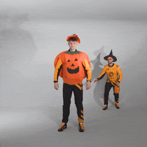 a man dressed as a pumpkin and a man dressed as a witch