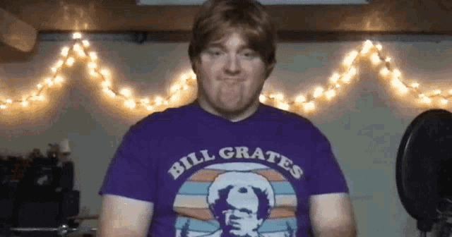 a man wearing a purple bill grates shirt makes a face