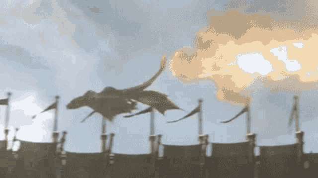 a dragon is flying over a castle with flames coming out of it 's mouth .
