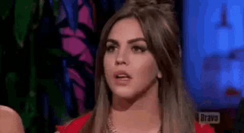 a woman in a red dress is making a funny face while sitting in front of a television .