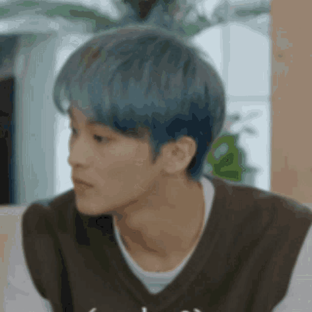 a close up of a person with blue hair wearing a brown vest and a white shirt .
