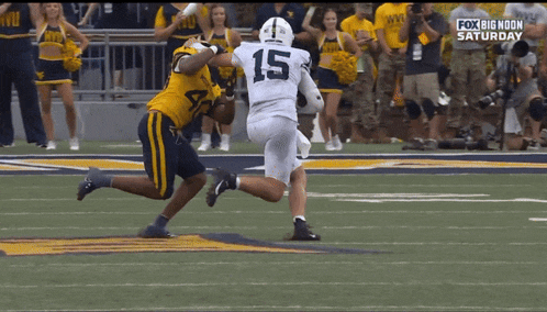 a football player with the number 15 on his jersey is being tackled by another player