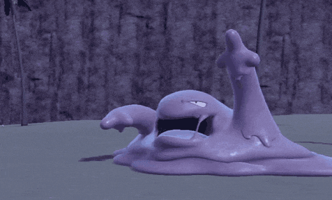a purple monster with its mouth open is laying on a concrete surface