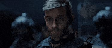 a man with a beard is wearing a helmet and earpiece