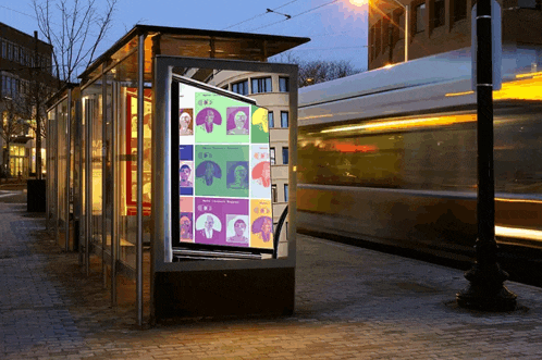 a bus stop with a poster on it that says ' i am a woman '