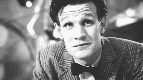 a man in a suit and bow tie is making a funny face .