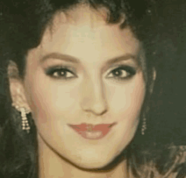 a close up of a woman 's face wearing earrings and lipstick .