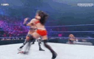 a woman in a red bikini is wrestling another woman in black tights