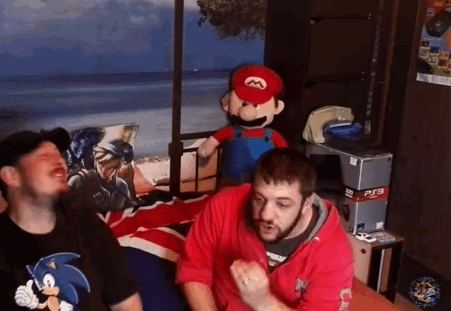 a man wearing a sonic shirt is sitting next to a man wearing a mario shirt