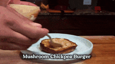 a person is making a mushroom chickpea burger with a spoon