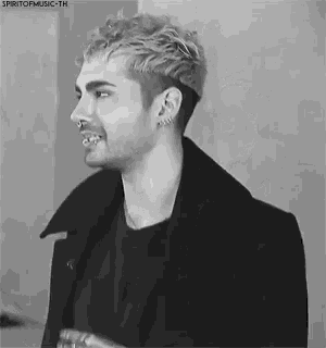 a black and white photo of a man with piercings in his nose and ear .