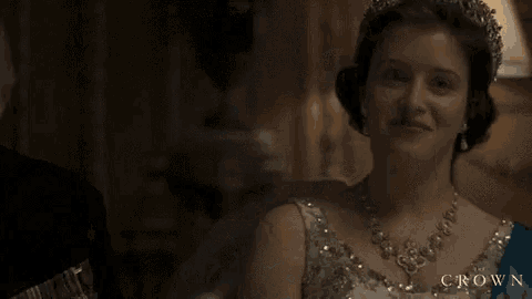 a woman is wearing a tiara and a necklace in a room .