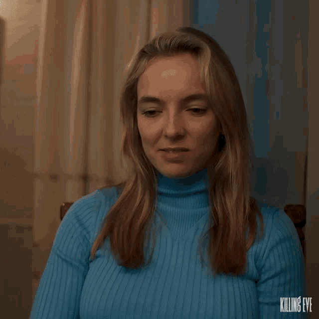 a woman in a blue sweater is sitting in front of a window with killing eye written on the bottom