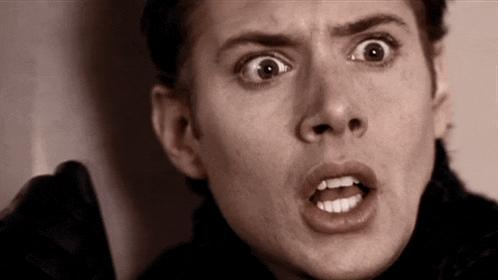 a close up of a person 's face with a surprised look on their face .