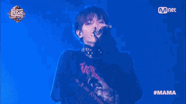 a man is singing into a microphone at a music awards show