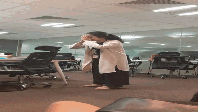 a woman is standing in a room with a sign that says ' office ' on it