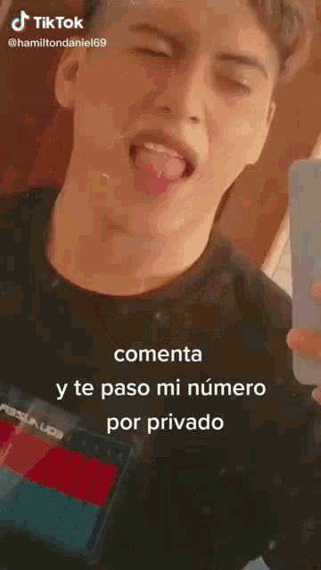 a young man is taking a picture of himself with his tongue hanging out and says " commenta " on the bottom