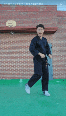 a person is doing a trick in front of a basketball hoop and a brick building