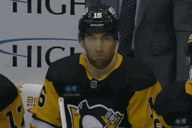 a hockey player wearing a helmet that says 16 on it