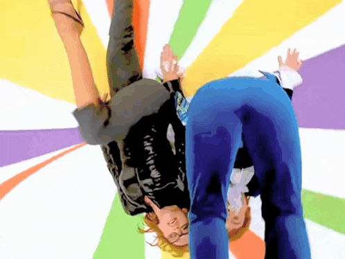 a person is upside down with a colorful background behind them