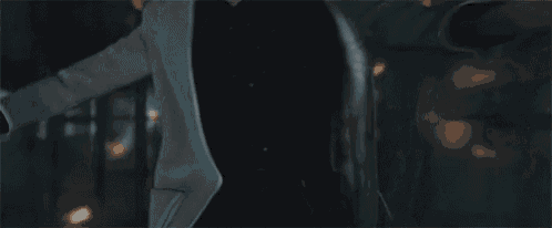 a man in a white coat is holding a knife in his hand .