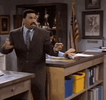 a man in a suit and tie stands in front of a desk
