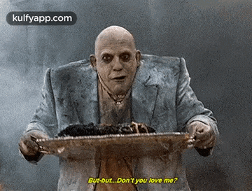a bald man in a suit is holding a tray of food and says `` but but ... don 't you love me ? ''