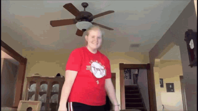 a woman in a red shirt with a t on it
