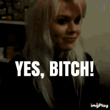 a woman with blonde hair is smiling and says yes , bitch !