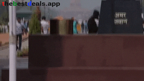 a man in a black hat is standing in front of a statue that says ' akbar jawan ' on it