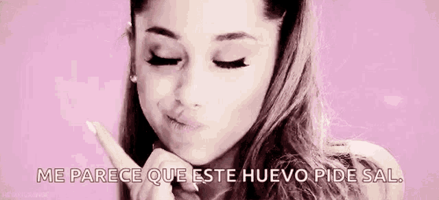 ariana grande is making a funny face while holding her hand to her face .