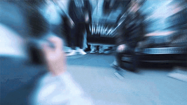 a blurry photo of people walking down a street with a car in the background