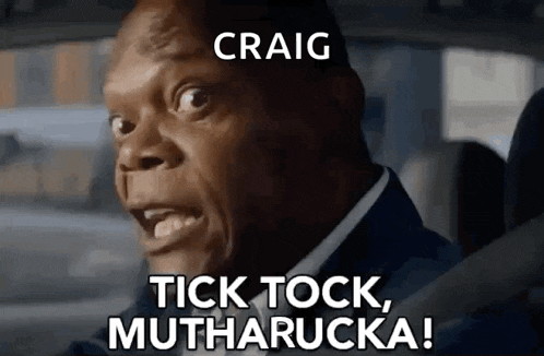 a man in a suit is driving a car and says `` tick tock , mutharucka ! ''