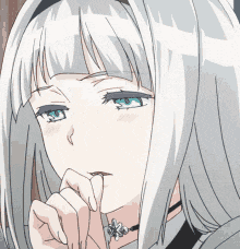 a girl with white hair and blue eyes has her hand on her chin .
