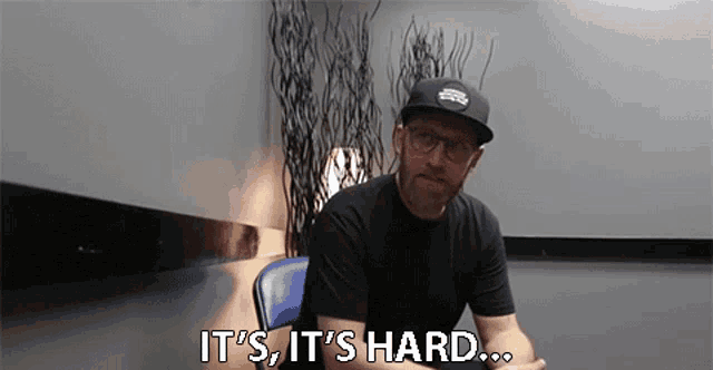 a man wearing a hat and glasses says it 's hard .