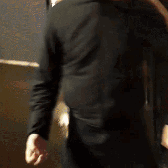 a man in a black shirt is standing in front of a mirror