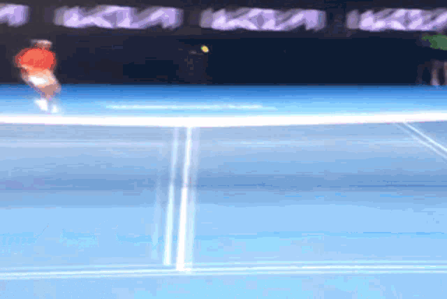 a blurred image of a tennis player on a blue court with a kia banner in the background
