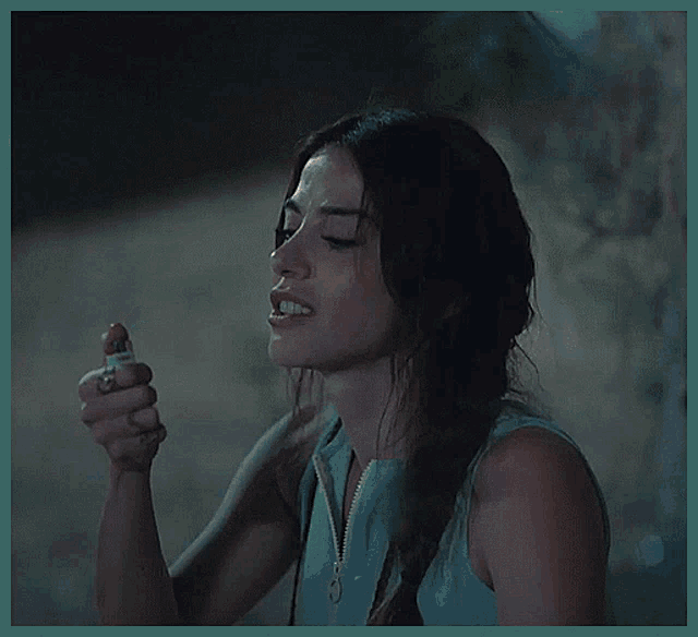 a woman is smiling while lighting a lighter