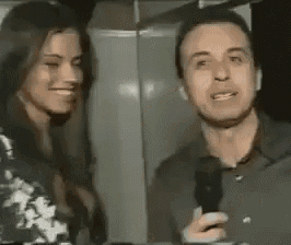 a man and a woman are standing next to each other and smiling .