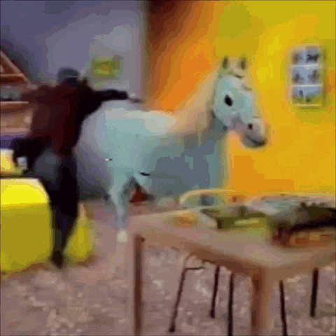 a white horse is standing in a room with a table and chairs
